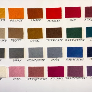 May include: A color chart featuring small, rectangular felt swatches in a variety of colors. The swatches are labeled with color names such as "Mustard," "Orange," "Amber," "Scarlet," "Red," and "Burgundy."