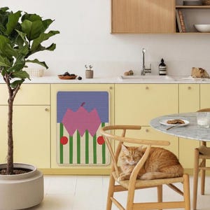 May include: A kitchen scene with a yellow cabinet and a colorful mat with a geometric design. A ginger cat rests on a wooden chair. A potted plant and a round table are also visible.