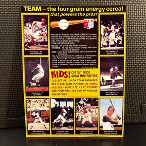 May include: A vintage advertisement for "TEAM" cereal featuring baseball players. The yellow and black poster includes images of players, a baseball bat and ball, and text promoting the cereal's nutritional benefits and mini-posters.