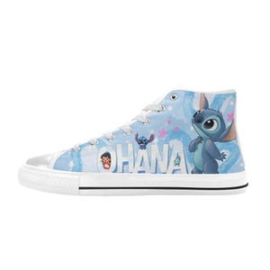 Puede incluir: Zapatillas altas de lona azul claro con un dise&ntilde;o de personaje de dibujos animados. Las zapatillas tienen una suela y cordones de goma blancos. La palabra "OHANA" est&aacute; impresa en el lateral, junto con im&aacute;genes del personaje.