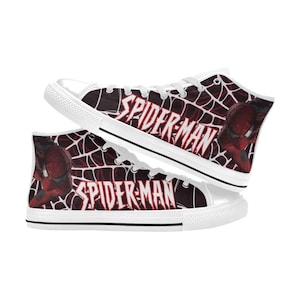 May include: High-top canvas sneakers featuring a Spider-Man design. The shoes have a white rubber sole and laces. The sides display a red and black web pattern with the words "SPIDER-MAN" and an image of Spider-Man.