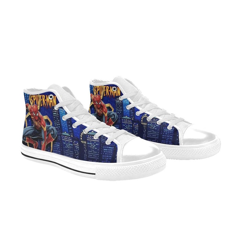 Op de afbeelding: Witte hoge sneakers met een Spider-Man-ontwerp. De sneakers hebben een blauwe stadsgezichtachtergrond met het Spider-Man-logo en karakterkunst. De schoenen hebben witte veters en zolen.