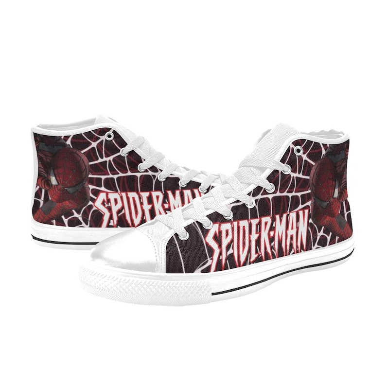 May include: Pair of high-top canvas sneakers featuring a Spider-Man design. The shoes have a white toe cap, laces, and tongue. The sides display a red and black web pattern with the words "SPIDER-MAN" and an image of Spider-Man.