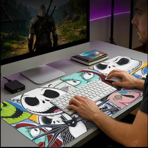 May include: A large rectangular mouse pad featuring a colorful collage of characters from The Nightmare Before Christmas. The design includes Jack Skellington's face, Sally, and other characters. A keyboard and mouse are on the pad.