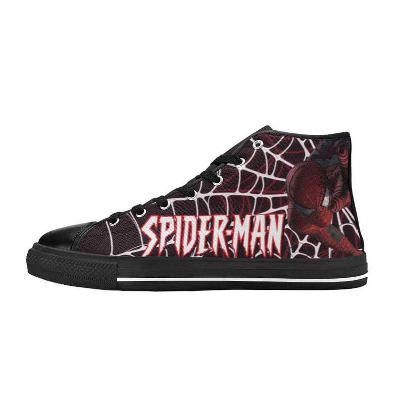 May include: High-top canvas sneaker featuring a Spider-Man design. The shoe has a black toe cap and sole with a white stripe. The side displays the Spider-Man logo in white and a red and black web pattern with a Spider-Man graphic.