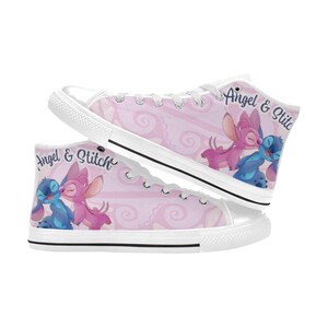 Puede incluir: Zapatillas altas de lona con un fondo rosa con un patr&oacute;n de remolino repetido. Las zapatillas muestran a los personajes Angel y Stitch en un abrazo amoroso. El texto "Angel & Stitch" est&aacute; impreso en el lateral.