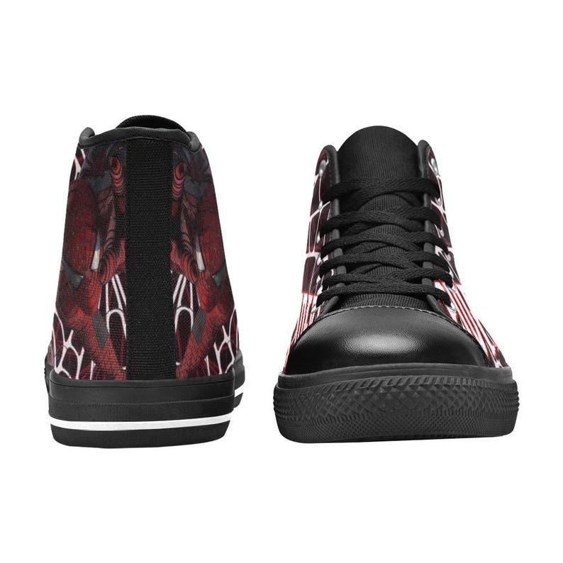 May include: High-top sneakers with a black rubber sole and black laces. The sneakers feature a red and white pattern on the sides and a red and black design on the back. The shoes have a black toe cap and a white stripe on the sole.