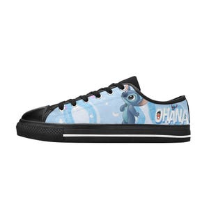 May include: A white ceramic mug with a black handle and the text "But First, Coffee" in a bold, black font. The mug is set against a blurred background, highlighting its simple design.