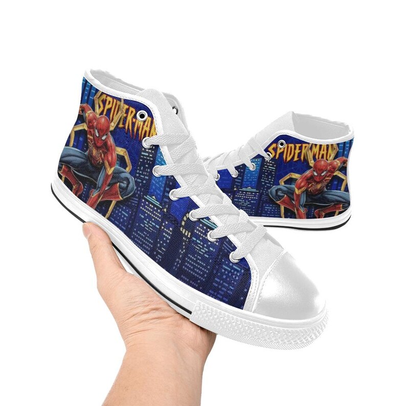 Op de afbeelding: Hoge canvas sneakers met een Spider-Man-ontwerp. De schoenen hebben een witte neus en veters, met een blauwe stadsgezicht achtergrond en een afbeelding van Spider-Man. Het woord "Spider-Man" staat op de zijkant.
