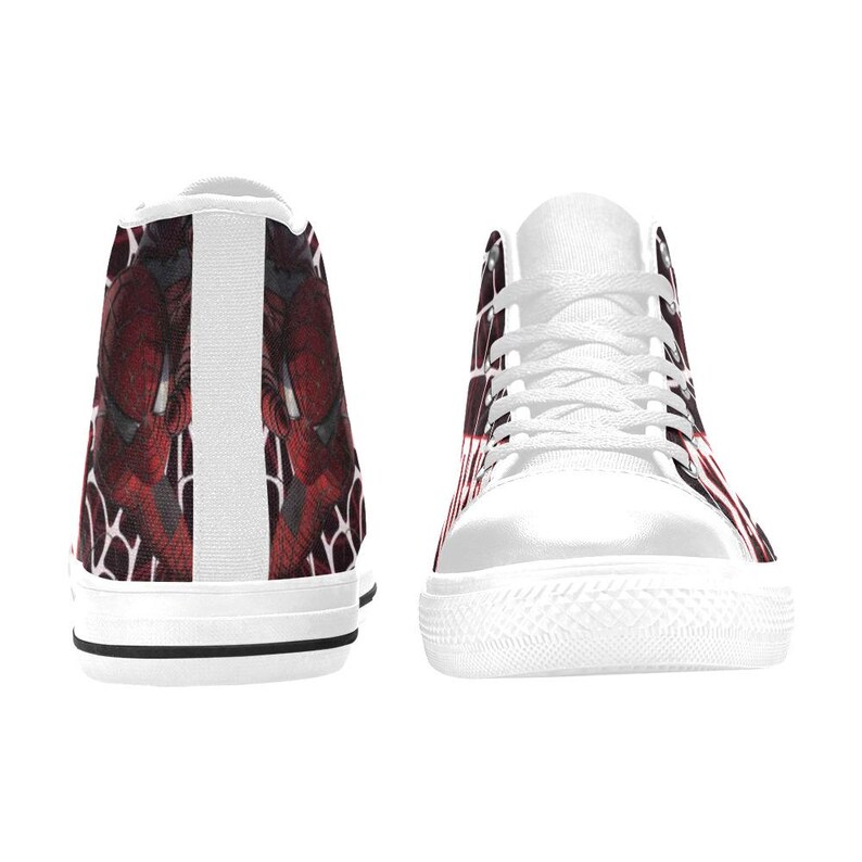 May include: White high-top sneakers with a red and black graphic design. The sneakers have white laces, a white sole, and a black stripe along the bottom. The design appears on the sides and back of the shoes.