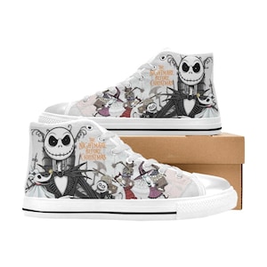 Puede incluir: Zapatillas altas blancas con personajes de "Pesadilla antes de Navidad". Los zapatos muestran a Jack Skellington, Sally y otros personajes en un dise&ntilde;o en blanco y negro. El texto "The Nightmare Before Christmas" tambi&eacute;n es visible.