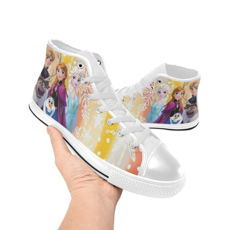 May include: White high-top sneakers featuring a colorful design with characters from the animated movie Frozen. The shoes have a white rubber sole, white laces, and a vibrant print of Elsa, Anna, Olaf, and other characters.