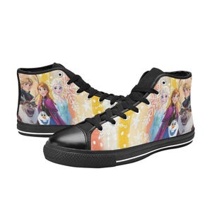 May include: High-top sneakers featuring a colorful design with characters from the animated movie "Frozen". The shoes have a black toe cap, black laces, and a black sole. The background has a yellow, orange, and white striped pattern.