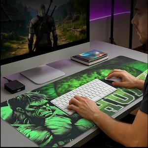 Könnte beinhalten: Eine grüne und schwarze Hulk-Themen-Mauspad-Erweiterung. Das Pad zeigt eine detaillierte Illustration von Hulks Gesicht und das Wort "Hulk" in fetten weißen Buchstaben. Eine weiße Tastatur und Maus befinden sich auf dem Pad.