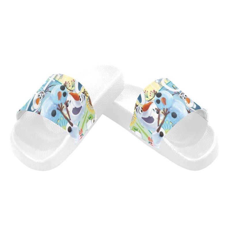 Puede incluir: Sandalias deslizantes blancas con un gr&aacute;fico colorido de Olaf de Frozen. Las sandalias tienen una plantilla texturizada y una correa ancha con el dise&ntilde;o del personaje. Perfectas para uso casual.