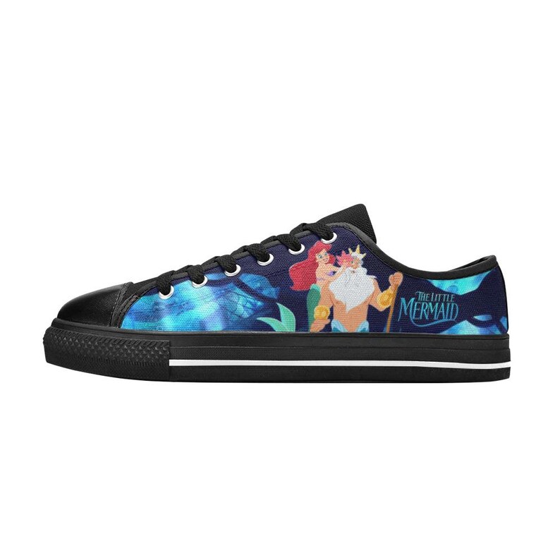 May include: Navy blue low-top canvas sneakers featuring a colorful illustration of Ariel and King Triton from The Little Mermaid. The sneakers have black laces, a black toe cap, and a black rubber sole with a white stripe.