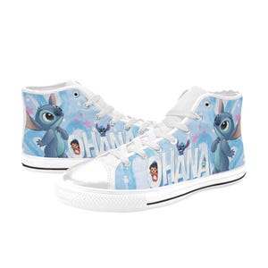 Puede incluir: Un par de zapatillas altas de lona con un fondo azul claro. Presentan el personaje de dibujos animados Stitch y la palabra "OHANA". Las zapatillas tienen cordones blancos, puntera blanca y suela blanca.