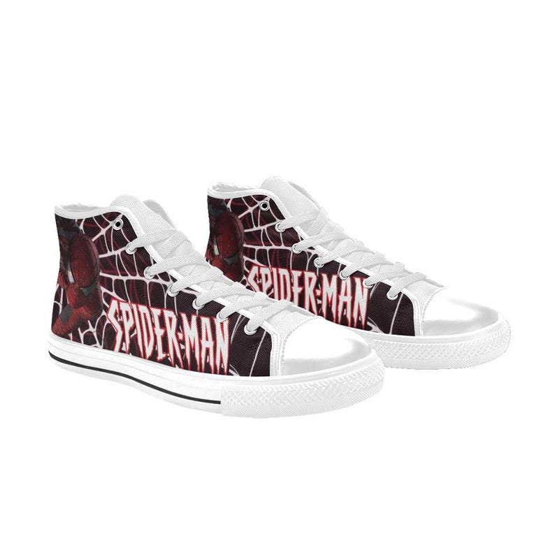 May include: High-top canvas sneakers featuring a Spider-Man design. The shoes have a white rubber sole and toe cap, with a black and red Spider-Man graphic and the text "SPIDER-MAN" on the sides. The laces are white.
