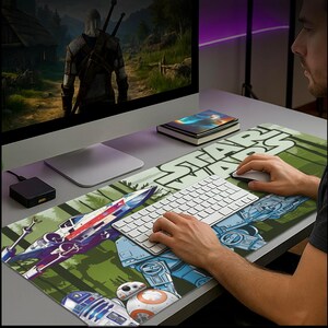 May include: A Star Wars-themed desk mat featuring iconic characters and vehicles, including X-wing fighters, R2-D2, and BB-8, set against a green and white background. The Star Wars logo is prominently displayed. A computer keyboard and mouse are on the mat.