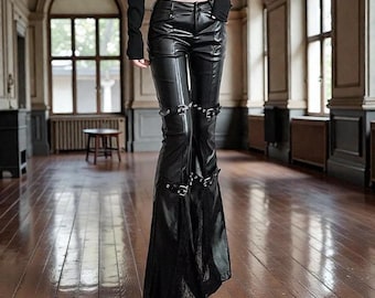 May include: Black faux leather pants with a flared leg design. The pants feature multiple silver buckles and straps along the legs. The pants have a high waist and a fitted silhouette, creating a bold and edgy look.