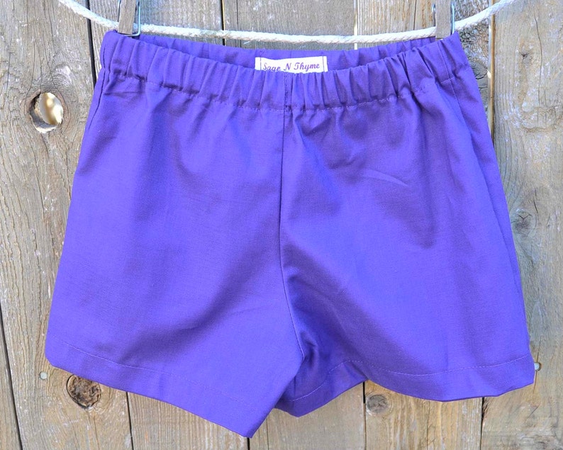 May include: Purple cotton shorts with an elastic waistband and a Sage N Thyme label.