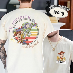 Peut inclure: T-shirt ivoire avec un motif color&eacute; de Woody et Buzz l'&Eacute;clair de Toy Story, avec le texte "TO INFINITY and beyond". Une petite image sur le devant montre Woody avec le nom "DAVID" en dessous.