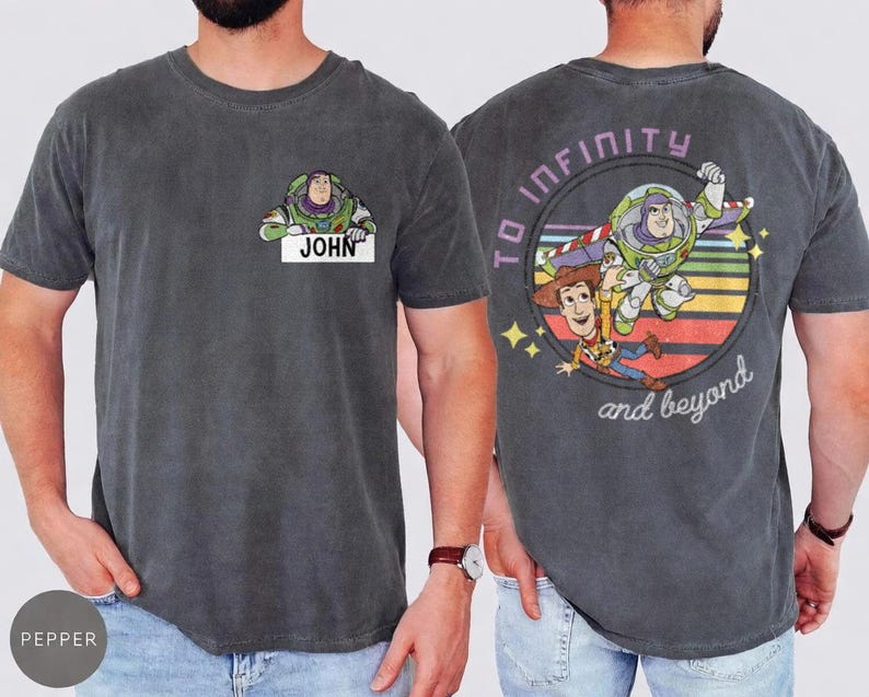 Peut inclure: T-shirt gris fonc&eacute; avec Buzz l'&Eacute;clair et le nom "JOHN" sur le devant. Le dos pr&eacute;sente un graphisme color&eacute; de Buzz l'&Eacute;clair et Woody, avec l'inscription "TO INFINITY and beyond".