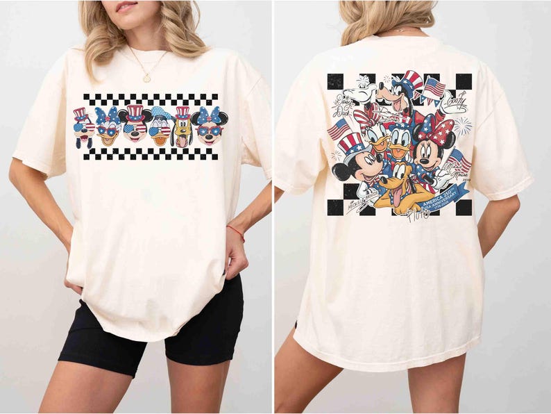 May include: Cream-colored t-shirt featuring a patriotic design with cartoon characters. The front displays a row of character faces above a black and white checkered pattern. The back showcases a group of characters with American flags and fireworks.
