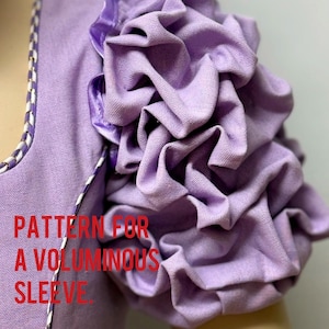 Könnte beinhalten: Nahaufnahme eines lila Kleidungsstücks mit einem voluminösen, gerüschten Ärmel. Der Ärmel ist aus einem weichen, strukturierten Stoff gefertigt. Der Text auf dem Bild lautet "PATTERN FOR A VOLUMINOUS SLEEVE."
