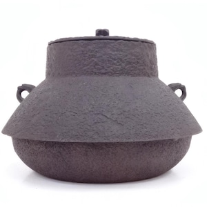May include: A dark brown, textured cast iron pot with a lid. The pot has a rounded base, a flared midsection, and two small handles. The lid has a small knob on top. The pot is likely used for cooking.