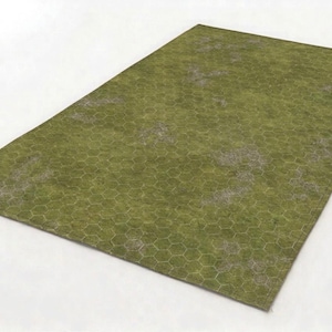 Op de afbeelding: Een rechthoekige groene en grijze speelmat met een zeshoekig patroon. De mat heeft een grasachtige textuur en is ontworpen voor bordspellen. De mat ligt op een witte ondergrond.