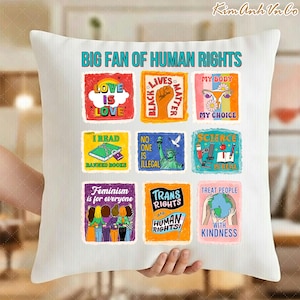 Op de afbeelding: Wit sierkussen met de tekst "BIG FAN OF HUMAN RIGHTS" en kleurrijke grafische vierkanten met berichten als "Love is Love", "Black Lives Matter" en "Treat People with Kindness".