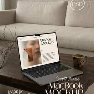 Peut inclure: Un ordinateur portable MacBook argenté affichant une "Maquette d'appareil" à l'écran, posé sur une table en bois sombre. Le texte "Organic Modern MacBook MOCKUP" est en dessous. Une tasse à café et un canapé sont en arrière-plan.