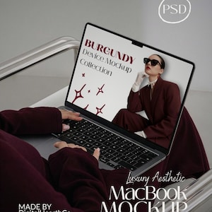 May include: A MacBook mockup with a burgundy theme. The screen displays "BURGUNDY Device Mockup Collection" and a woman in a burgundy suit. The laptop is on a white chair. The text "Luxury Aesthetic MacBook MOCKUP" is also visible.
