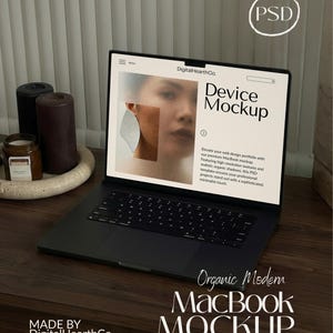 May include: A black MacBook laptop with a screen displaying a website mockup. The screen shows the text "Device Mockup" and "Organic Modern MacBook Mockup". The laptop is on a wooden desk, with candles and a decorative tray in the background. The text "MADE BY DigitalHearthCo" is also visible.