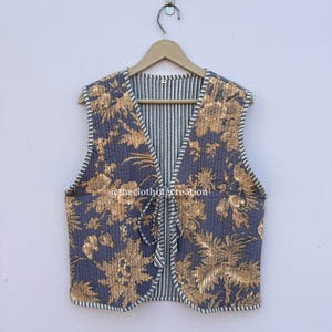 Gewatteerd katoenen vest, omkeerbaar met bloemenprint en striksluiting aan de voorkant.