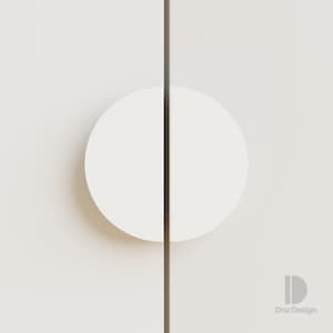Könnte beinhalten: Nahaufnahme einer weißen Schranktür mit einem halbkreisförmigen Griff. Der Griff befindet sich auf der linken Seite der Tür, mit einer dunklen vertikalen Linie in der Mitte. Das Design ist minimalistisch und modern. Das Logo "Dnz Design" befindet sich unten rechts.
