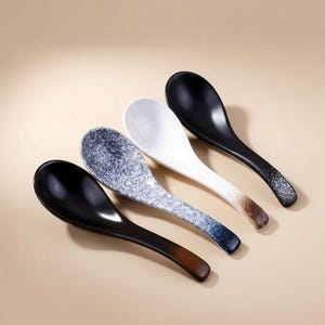 Puede incluir: Cuatro cucharas de sopa de cerámica en diseños negro, blanco y moteado. Las cucharas tienen forma de cuenco profundo y mangos largos. Los mangos hacen la transición del color principal a un tono marrón o azul.