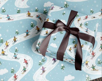 May include: Light blue wrapping paper with a repeating pattern of skiers, snow, and trees. A wrapped gift with a brown satin ribbon is on top of the paper. The skiers are wearing colorful outfits.