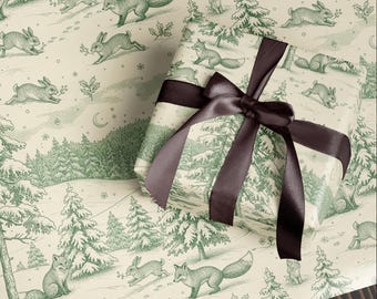 May include: Gift-wrapped present with a dark brown satin ribbon. The wrapping paper features a winter scene with foxes, rabbits, trees, and a crescent moon in a green and cream color scheme. The paper is printed with a toile design.