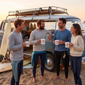 Peut inclure: Quatre personnes sur une plage, tenant des mugs avec un cœur, près d'un van bleu vintage avec des planches de surf. Ils portent des pulls et des combinaisons de plongée, profitant du coucher de soleil. Des planches de surf sont appuyées contre le van.