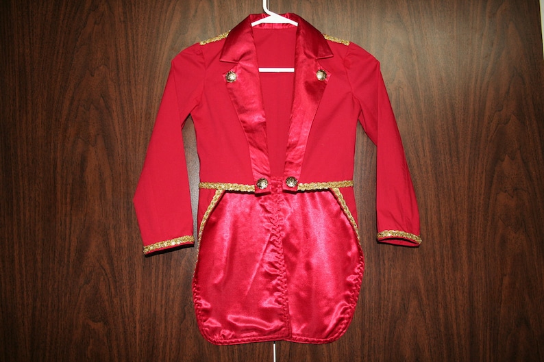 Puede incluir: Una chaqueta de disfraz roja y dorada para ni&ntilde;os con forro de sat&eacute;n y ribetes dorados. La chaqueta tiene una cola larga y es perfecta para un disfraz de maestro de ceremonias o director de orquesta.