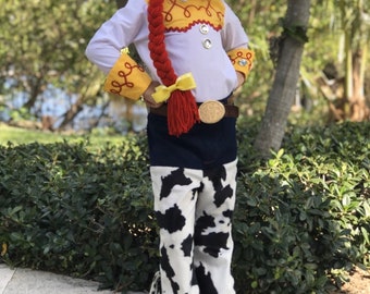 Disfraz de Jessie de 4 piezas. Incluye: camisa con anilla, pantalones con polainas de piel sintética, cinturón de piel sintética y hebilla de imitación de Toy Story.