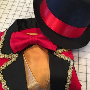 May include: A black and red ringmaster costume with gold trim. The costume includes a jacket, bow tie, and top hat.