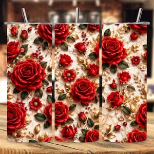 May include: Three stainless steel tumblers with a floral design. The tumblers feature a pattern of red roses, buds, and smaller red flowers on a white and gold background. Each tumbler has a silver straw.