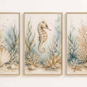 Könnte beinhalten: Set aus drei gerahmten Aquarelldrucken mit Küstenmotiv. Jeder Druck zeigt Meereslebewesen, darunter Muscheln, Korallen und Seetang, mit einem Seepferdchen im zentralen Druck. Das Kunstwerk ist in sanften, gedämpften Tönen von Beige, Blau und Grün gehalten.