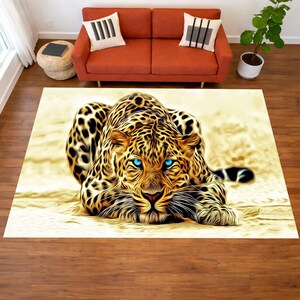 May include: A rectangular area rug featuring a detailed illustration of a leopard with striking blue eyes. The leopard's fur is a mix of gold and black, with a light beige background. The rug is placed on a wooden floor.