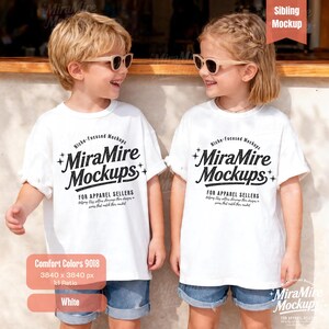 May include: Two children wearing white t-shirts with the text "MiraMire Mockups" in black. The shirts are paired with denim shorts and sunglasses. The image also includes text that says "Comfort Colors 9018" and "White".