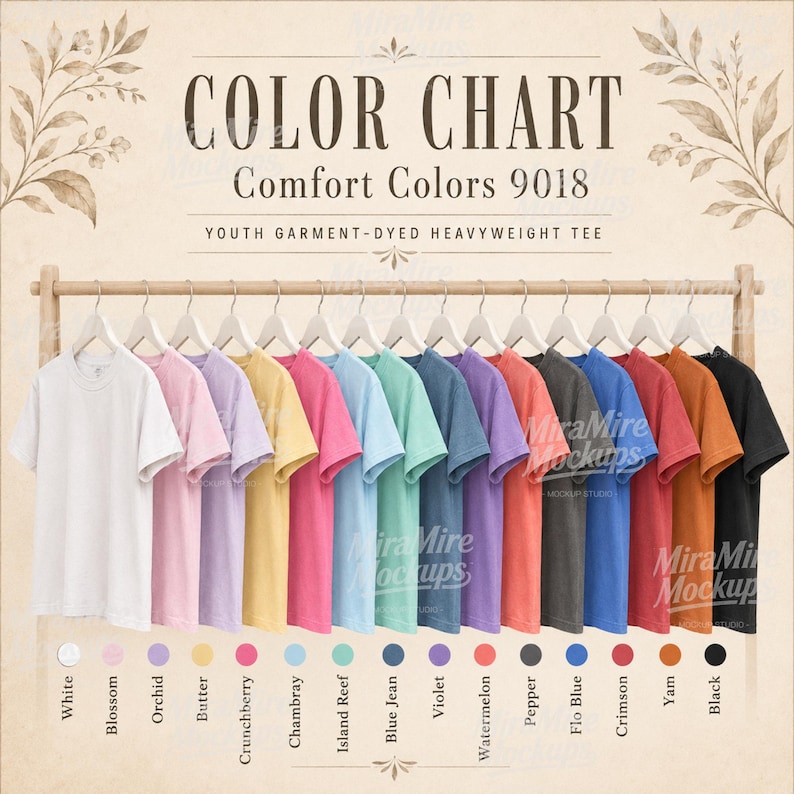 May include: A color chart for Comfort Colors 9018 youth garment-dyed heavyweight t-shirts. The image displays fifteen t-shirts in various colors hanging on a wooden rack, with corresponding color names listed below each shirt on the chart.