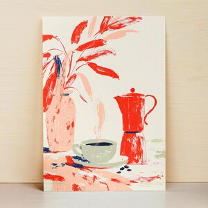 Könnte beinhalten: Ein rechteckiger Kunstdruck mit einer stilisierten Illustration einer hellrosa Vase mit rotem Blattwerk, einer hellgrünen Teetasse mit dunkler Flüssigkeit und einer leuchtend roten Espressokanne. Die Komposition zeigt verstreute Kaffeebohnen.